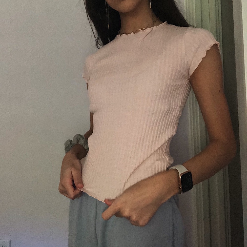 Pink tight shirt with ruffle sleeves.